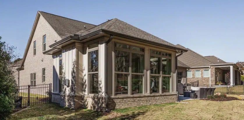 Finished sunroom addition with large windows on brick home. Home addition project by Potts Brothers Construction, Arlington & Northern Virginia