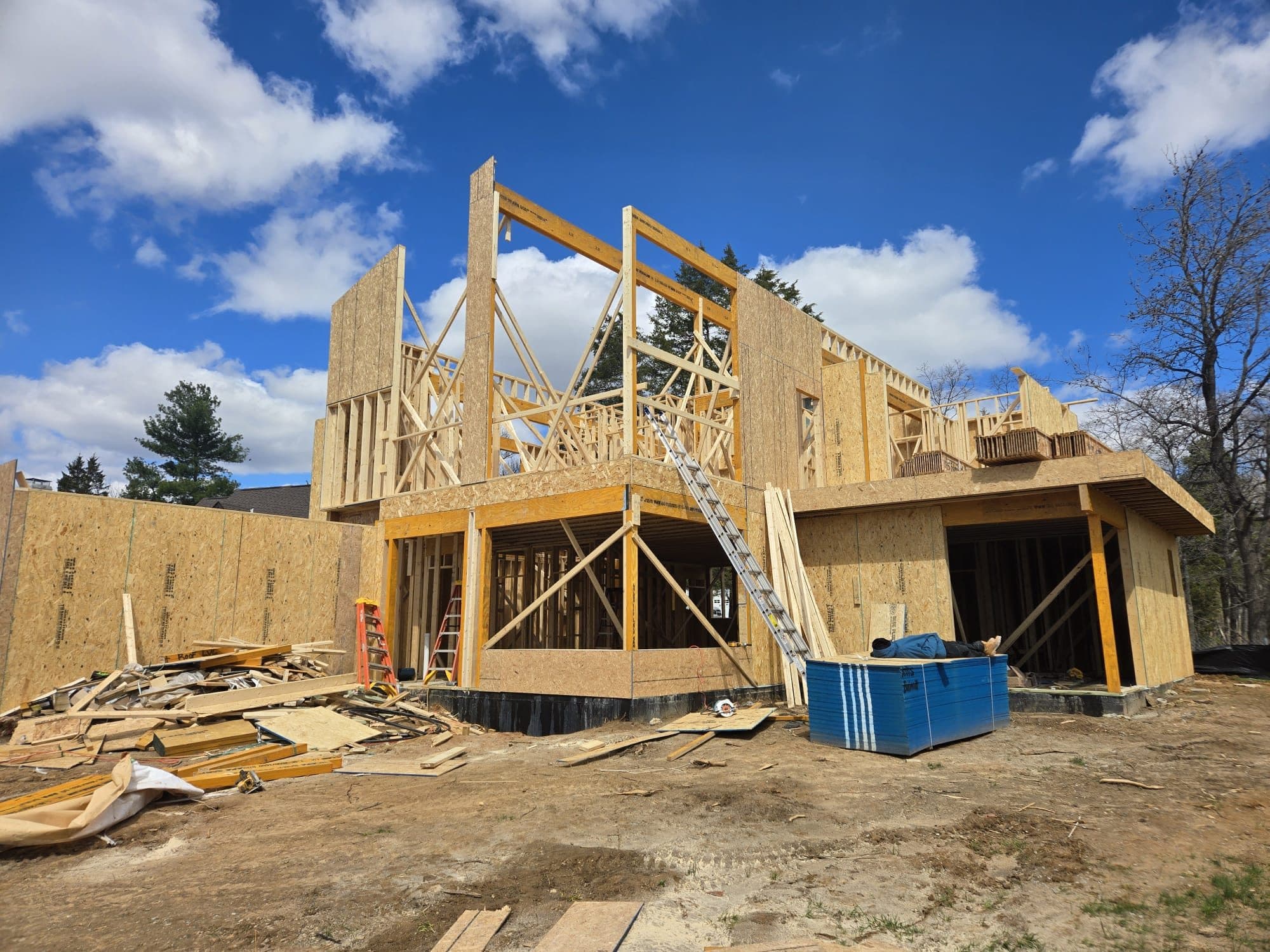 Large two-story home addition during framing stage with exposed studs and trusses. Home addition project by Potts Brothers Construction, Arlington & Northern Virginia