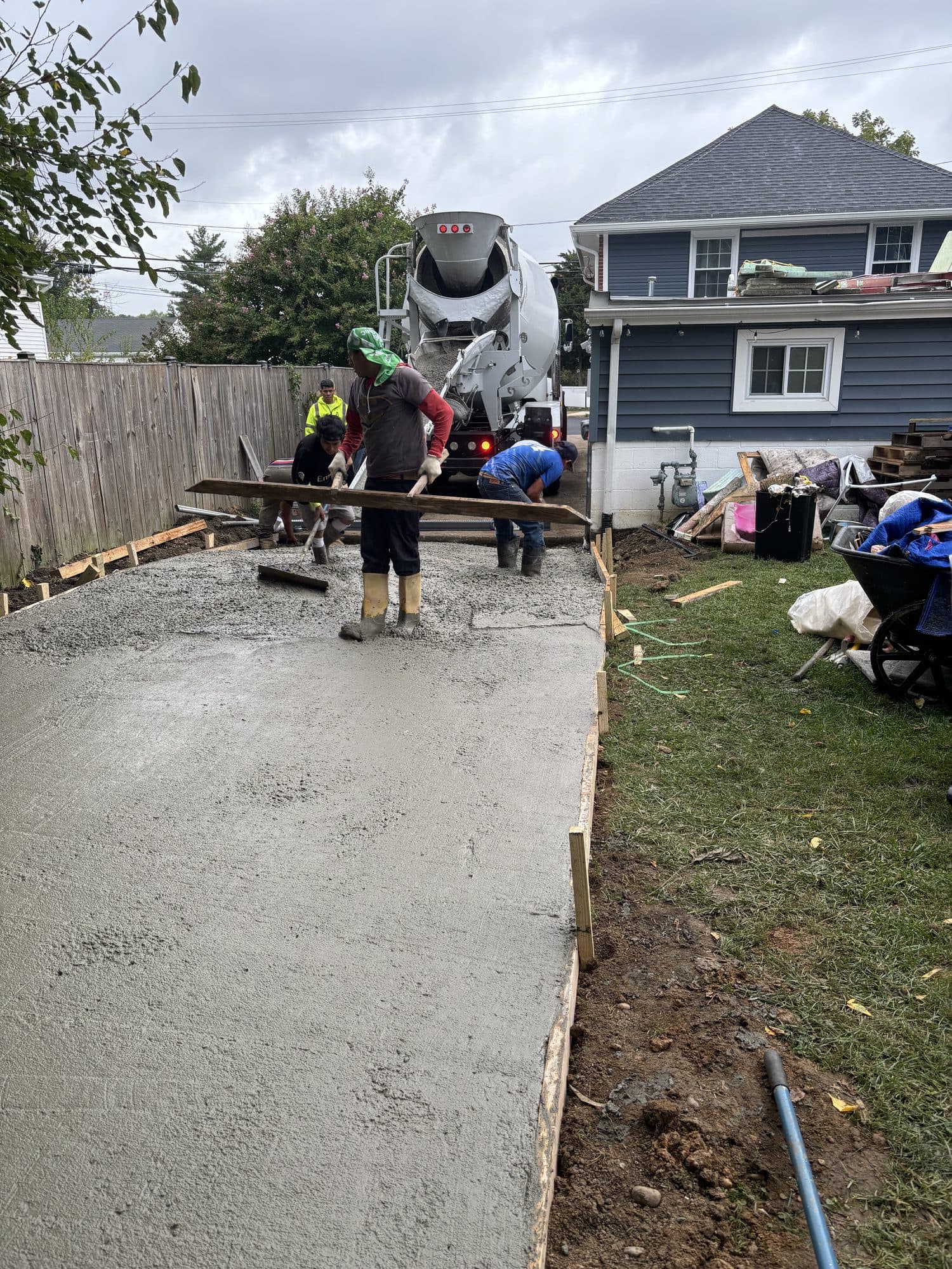 Crew finishing freshly poured concrete driveway slab. Concrete project by Potts Brothers Construction, Arlington & Northern Virginia