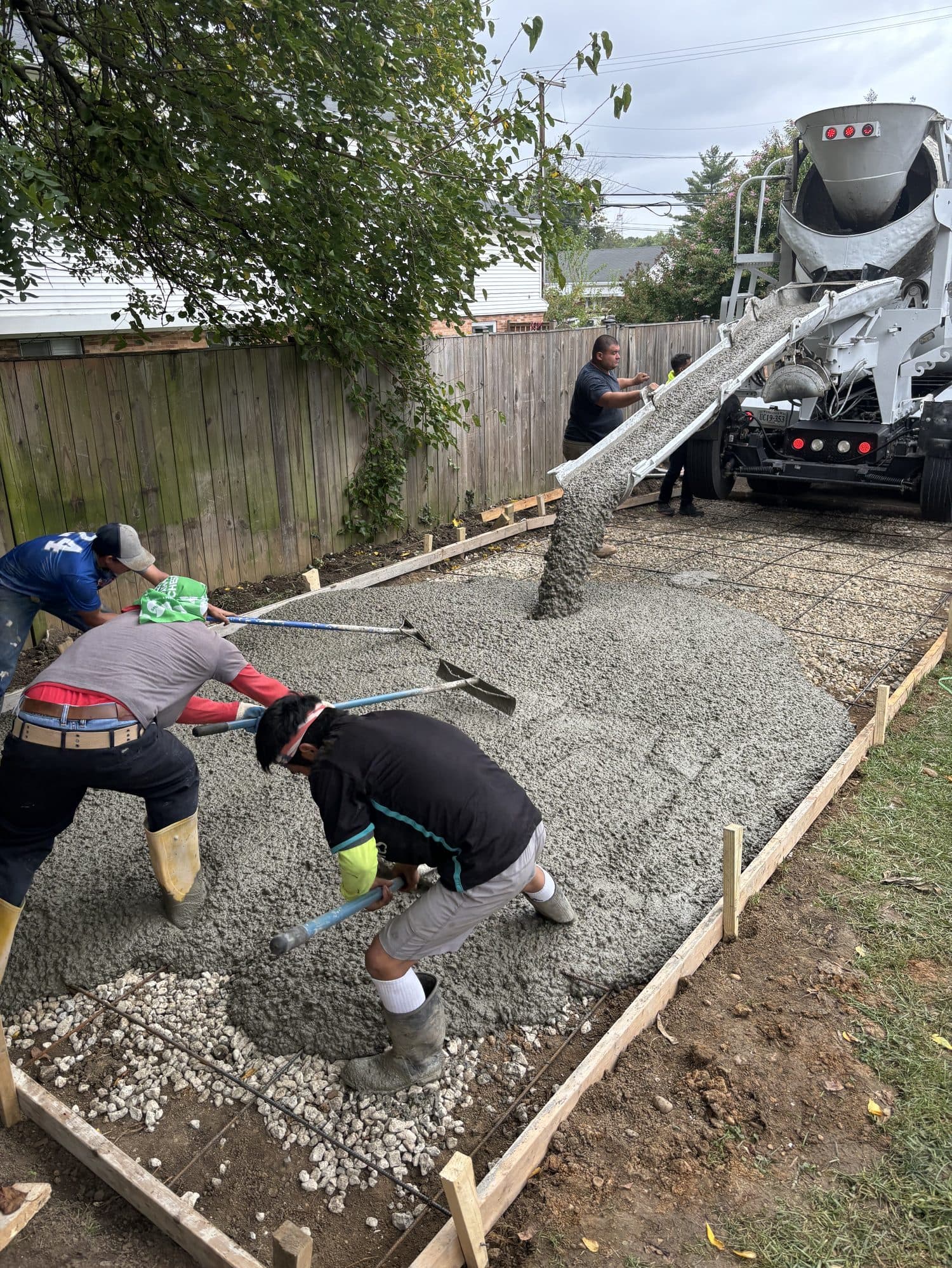 Crew placing and screeding wet concrete patio pour. Concrete project by Potts Brothers Construction, Arlington & Northern Virginia