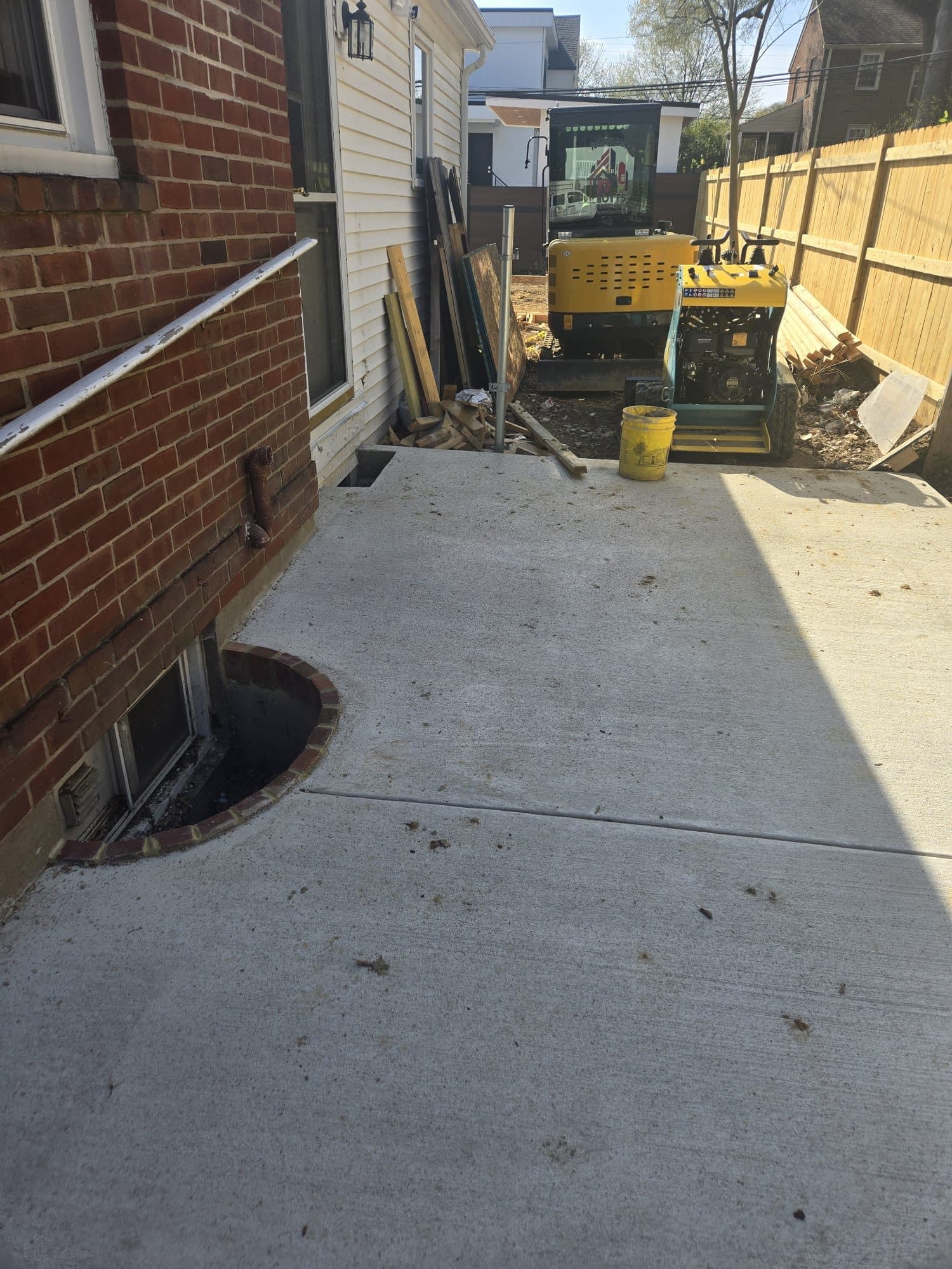 Finished concrete walkway alongside brick house. Concrete project by Potts Brothers Construction, Arlington & Northern Virginia