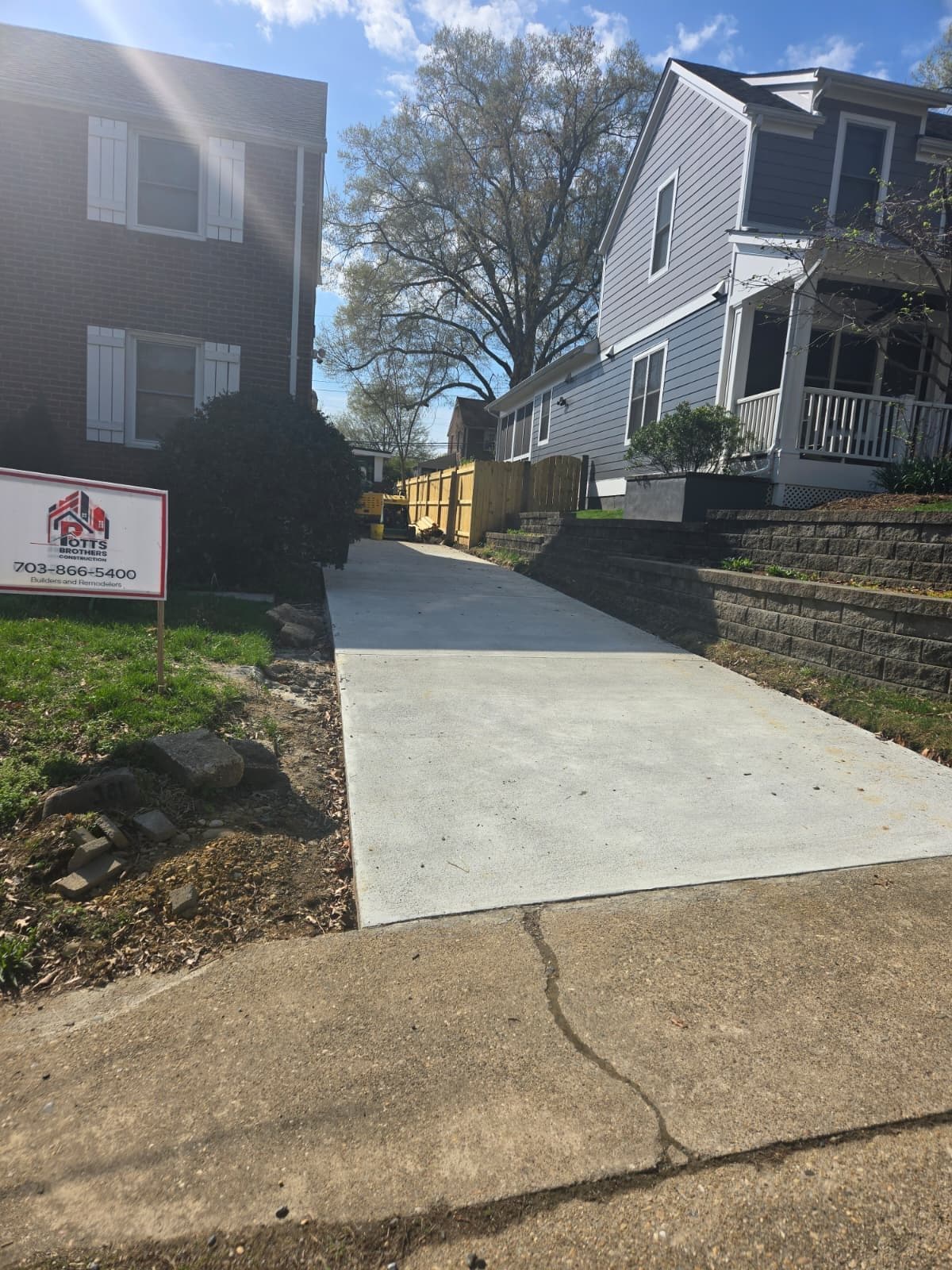 Freshly poured concrete driveway between two homes. Concrete project by Potts Brothers Construction, Arlington & Northern Virginia