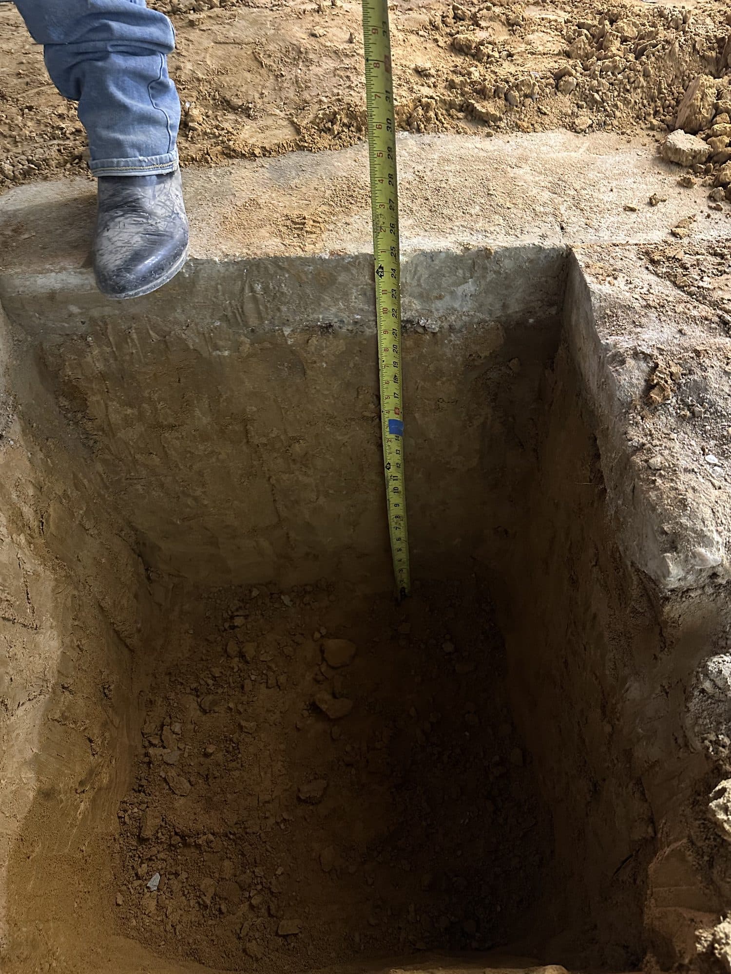 Measuring depth of footing excavation pit. Foundation project by Potts Brothers Construction, Arlington & Northern Virginia