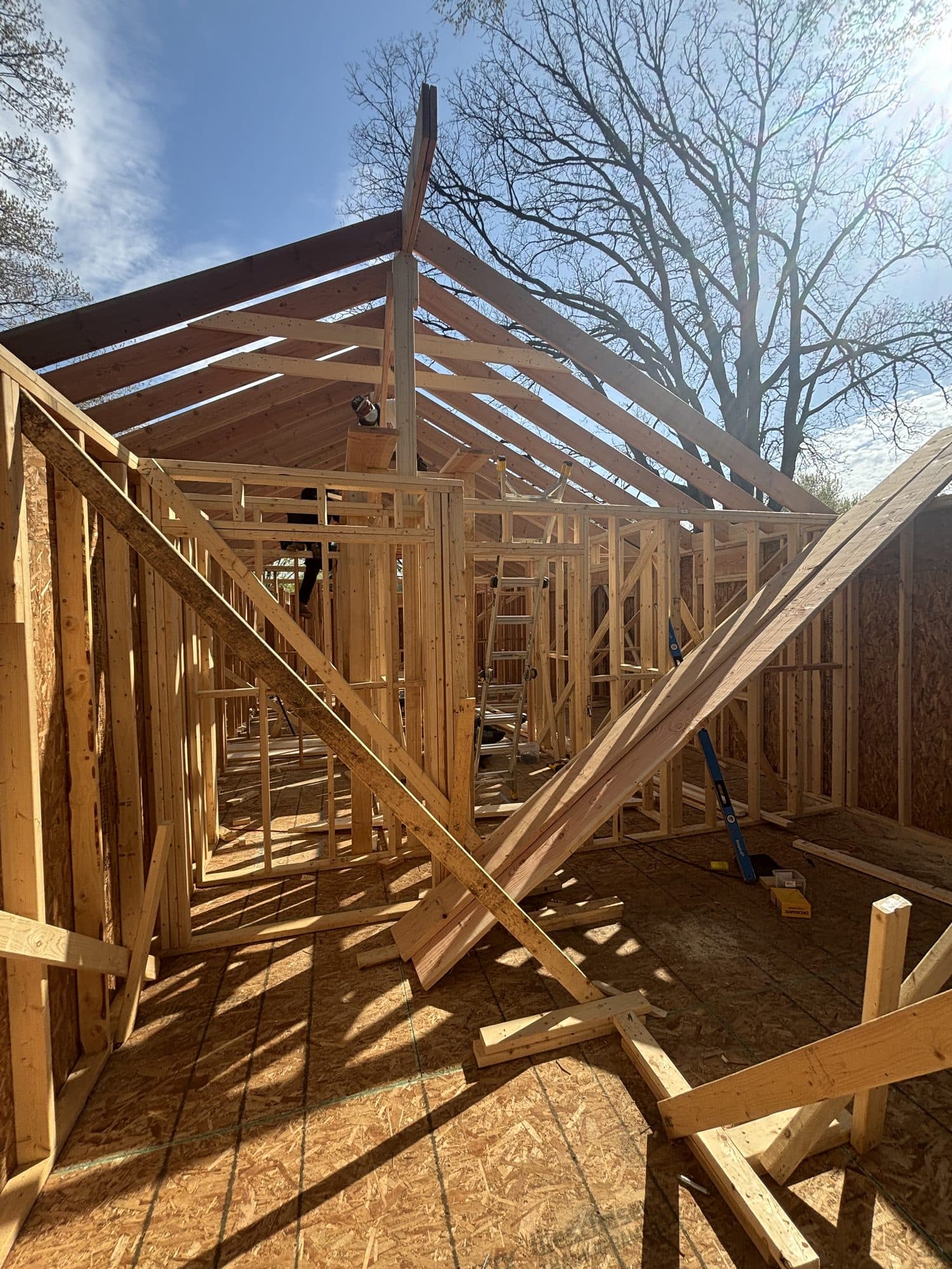 Interior of a detached garage under construction with framed walls, rafters, and diagonal bracing. Garage project by Potts Brothers Construction, Arlington & Northern Virginia