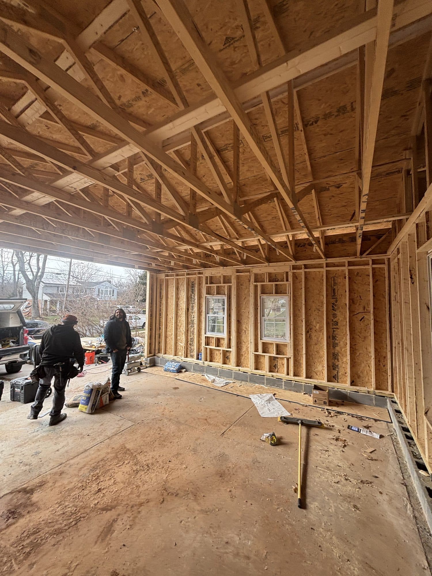 Interior garage addition framing with trusses and workers. Garage project by Potts Brothers Construction, Arlington & Northern Virginia